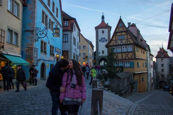 Couple kissing on cobbled street before the Plönlein, Rothenburg ob der Tauber