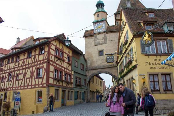 A couple embraces before the Markusturm among half-timbered houses in Rothenburg