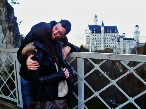 Couple embracing on a bridge in front of Neuschwanstein Castle