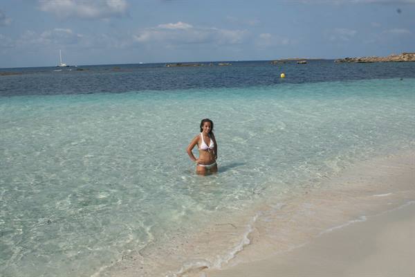 Woman in bikini in the crystal-clear turquoise water of a white sand beach