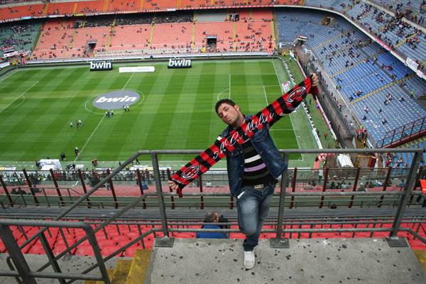 AC Milan fan waving scarf at San Siro stadium, Milan