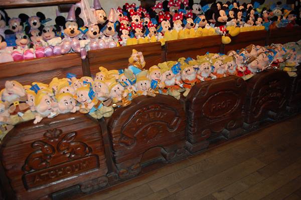 Seven Dwarfs and Disney plush toys on carved wooden carts