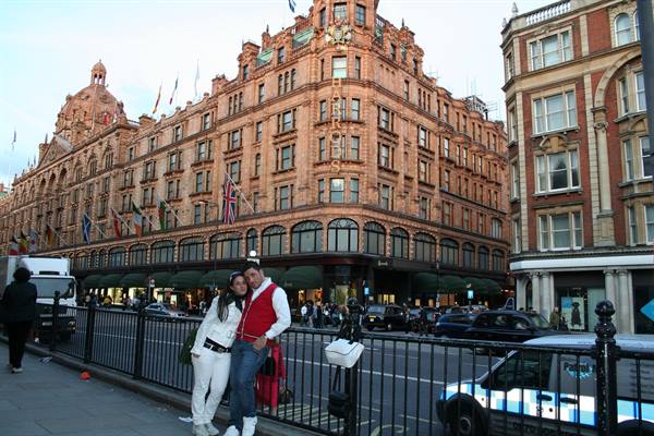 Couple posing in front of Harrods department store in London