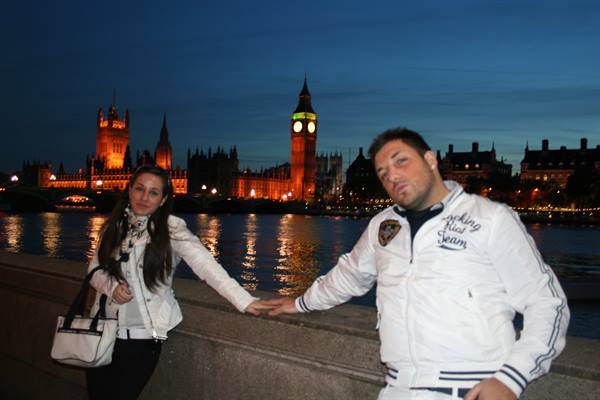 Couple in white jackets along the Thames, Big Ben lit up at night