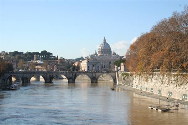 Tiber river flows beneath Sant'Angelo bridge, St. Peter's dome
