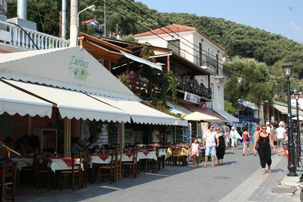 Zorbas taverna with white awnings along busy Skiathos waterfront