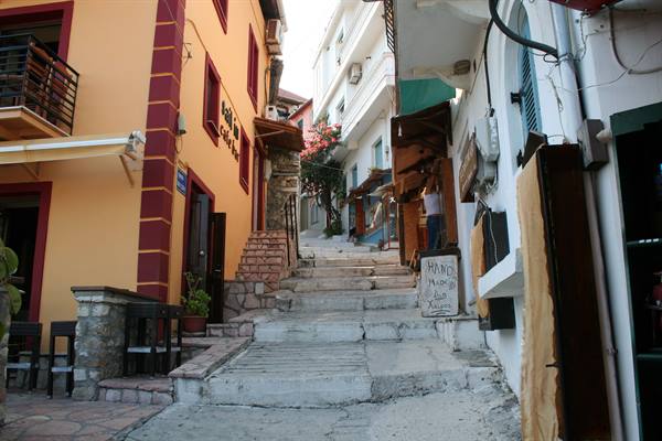 Stone staircase between colorful houses, souvenir shop and blooming bougainvillea