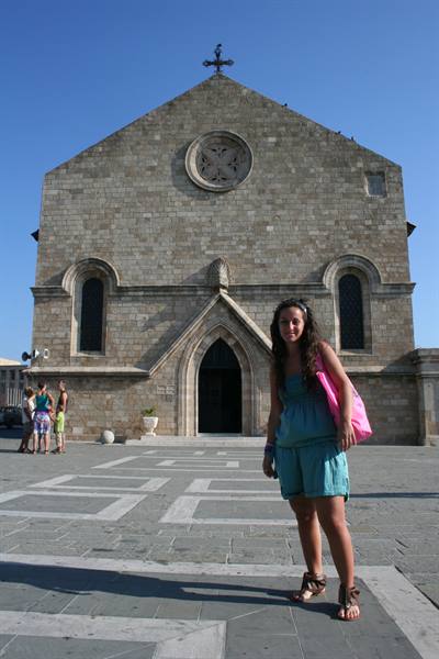 Girl in front of the medieval stone church in Rhodes