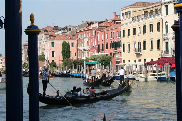 Gondoliers with tourists on black gondolas along Venice's Grand Canal