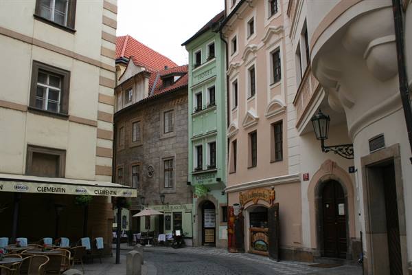 Cobbled alley with colorful facades and outdoor café in Prague