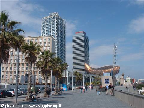 Barceloneta promenade in Barcelona with Gehry's copper fish sculpture and palm trees