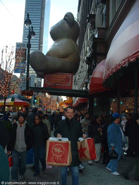 Man carrying shopping bags in front of Macy's giant teddy bear, New York