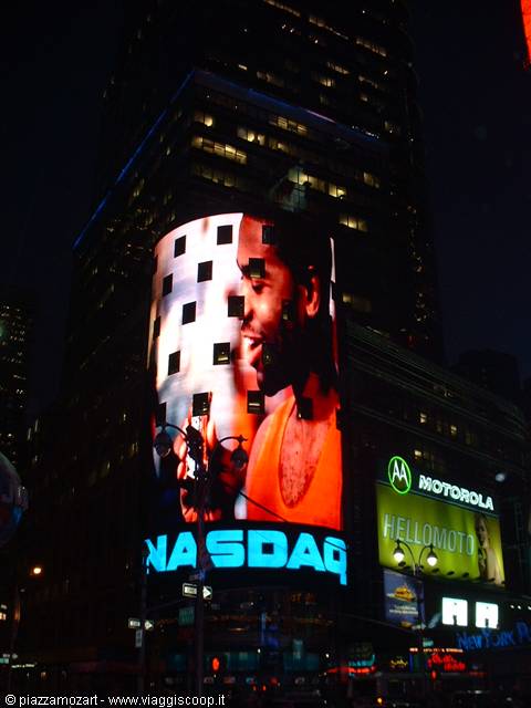 Times Square at night: glowing NASDAQ screen and Motorola signs on skyscrapers