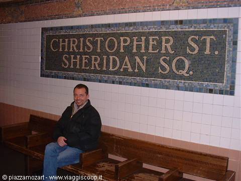 Man sitting on wooden bench at Christopher St. Sheridan Sq. subway station, New York
