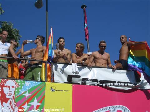 Guys on a float with rainbow flags at Rome Pride parade