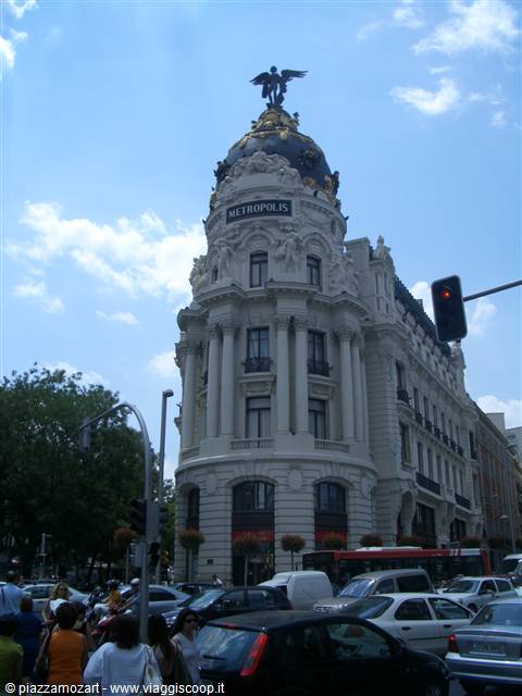 Metrópolis building in Madrid, white façade with dome and golden angel, traffic below