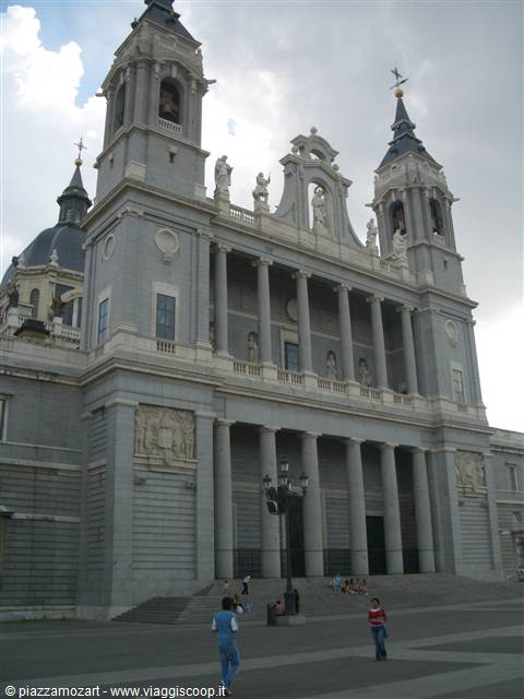 Almudena Cathedral in Madrid, grey colonnaded facade with tourists below