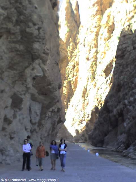 Women walking on the narrow road between the towering rock walls of Todra Gorge