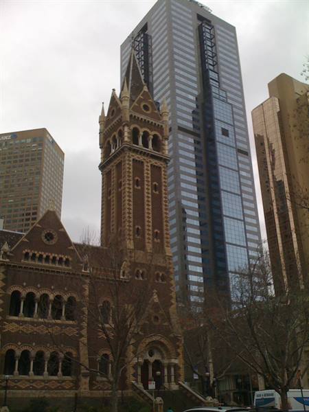 Brick Gothic church tower rising among Melbourne skyscrapers