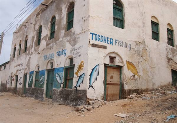 Togdher Fishing, old whitewashed building painted with fish murals