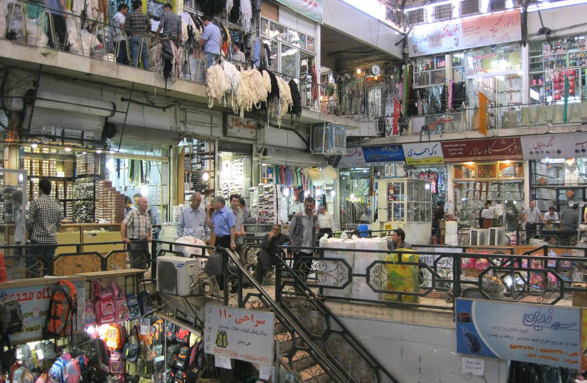 Bazar coperto su due piani, negozi di vestiti e passanti tra insegne in persiano