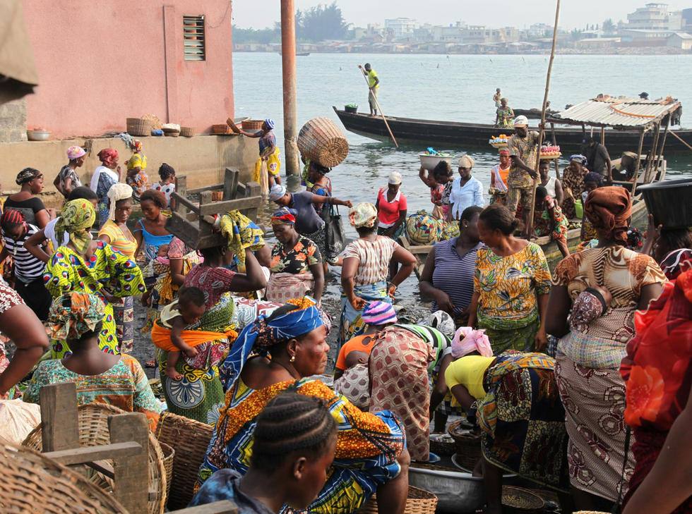 Donne con vestiti colorati e ceste al mercato sul porto di Elmina