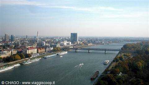 Bridges over the Danube in Bratislava, skyscraper and boats moored along the banks