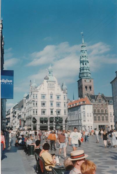 Crowded pedestrian street in Copenhagen, St Nicholas tower and Illum sign