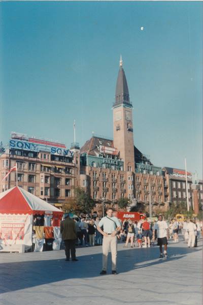 Tourist posing in a square in front of the Palace Hotel tower
