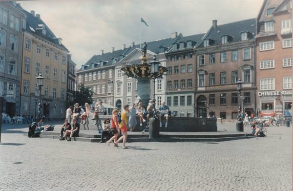 Tourists sitting around the Stork Fountain on Amagertorv square, Copenhagen