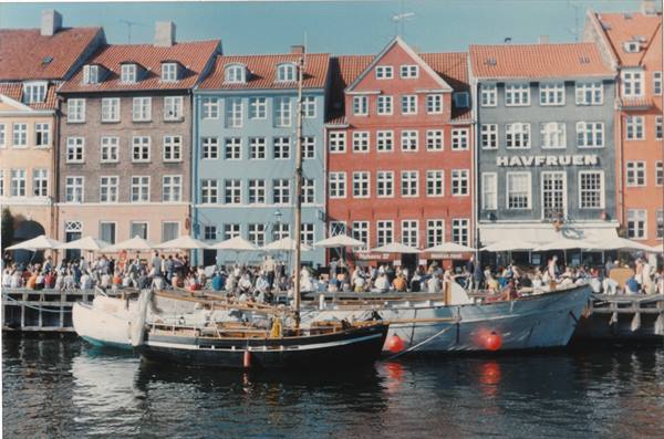 Nyhavn: boats moored in front of colorful houses and crowded cafes