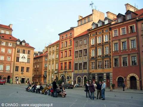 Tourists sitting and standing on the cobbled Old Town square in Warsaw