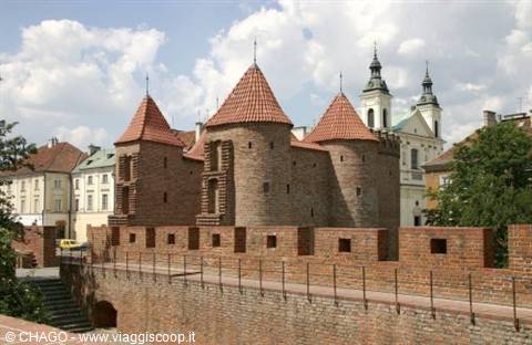 Warsaw Barbican, red brick towers with conical roofs under white clouds