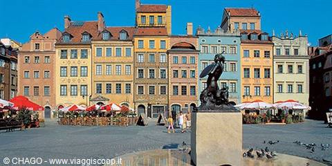 Mermaid statue on fountain in Warsaw Old Town square, colorful houses behind