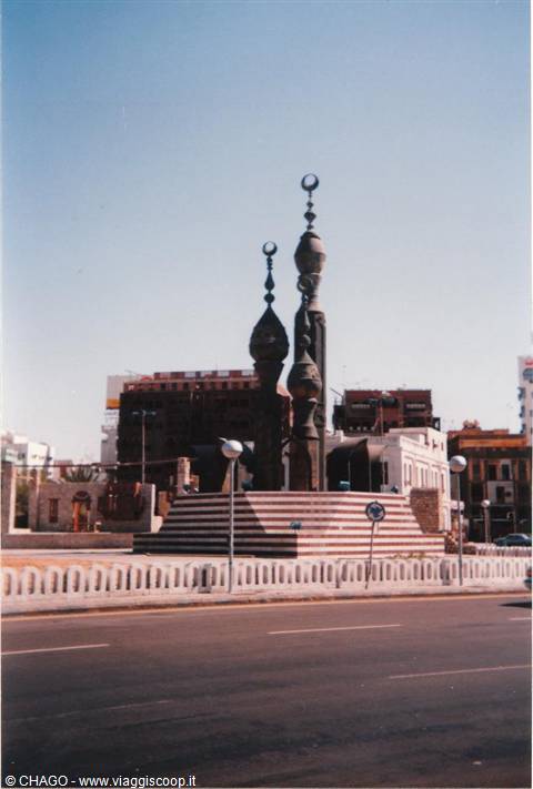 Bronze monument with crescent moons on striped red and white roundabout