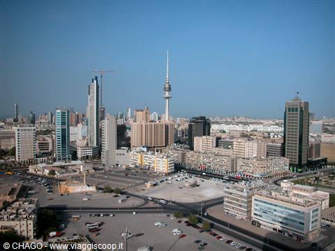 Skyscrapers and Liberation Tower above Kuwait City parking lots, clear daylight