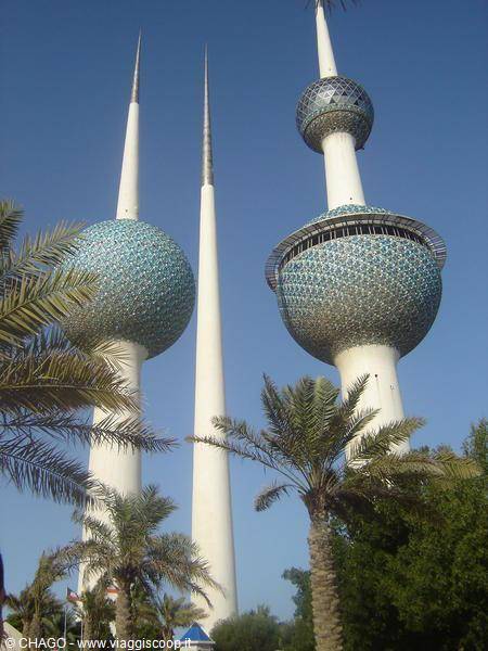 Kuwait Towers with blue mosaic shells rising among palm trees