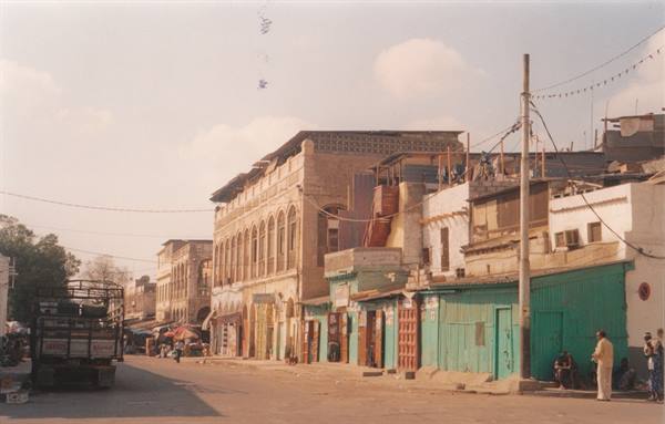 street with old stone buildings and shops with green shutters