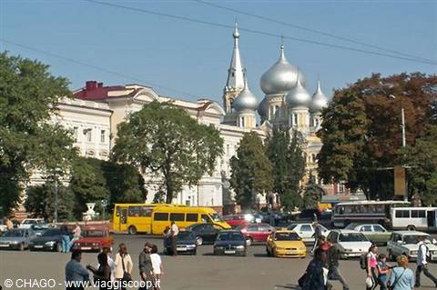 Silver-domed cathedral in Odessa, traffic and pedestrians crossing the sunny square
