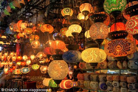 Colorful mosaic glass Moroccan lanterns hanging in a market, warm glowing light