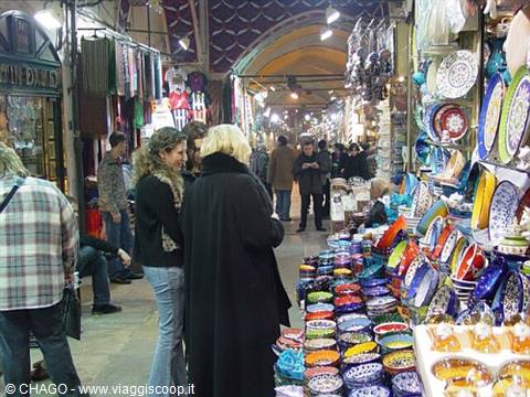 Tourists browsing colorful ceramics at Istanbul's Grand Bazaar
