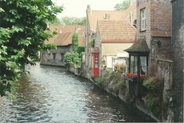 Canal lined with brick houses and flower boxes in Bruges