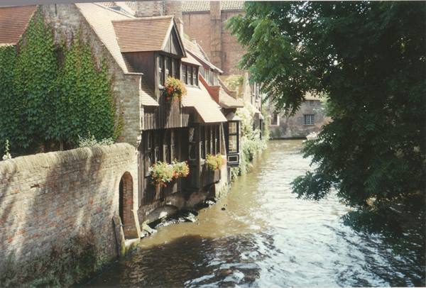 Wooden houses with flowers along the canal in Bruges