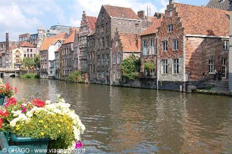 Medieval brick houses along Ghent's canal, flowers in the foreground