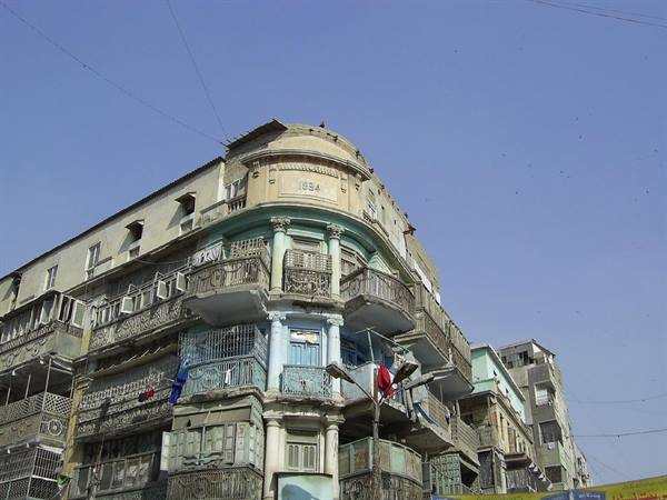 Colonial building with iron balconies, rounded corner, blue sky
