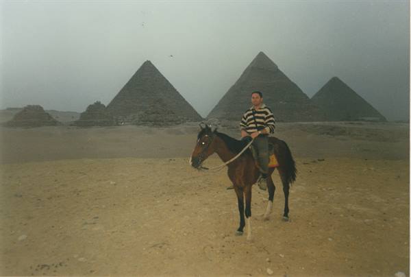 on horseback at the foot of the Pyramids