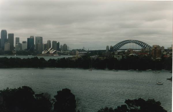 Sydney Harbour with the Opera House and Harbour Bridge under cloudy skies