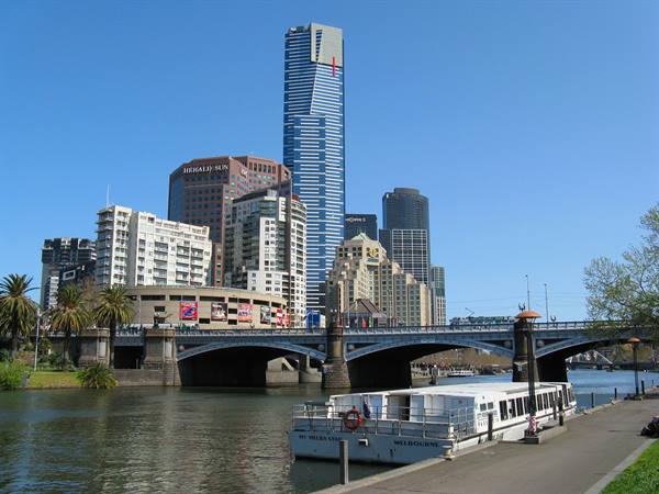 Ferry on the Yarra River in front of Melbourne's bridge and skyscrapers