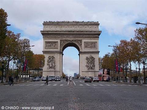 Arc de Triomphe in Paris, pedestrians cross the road under cloudy sky