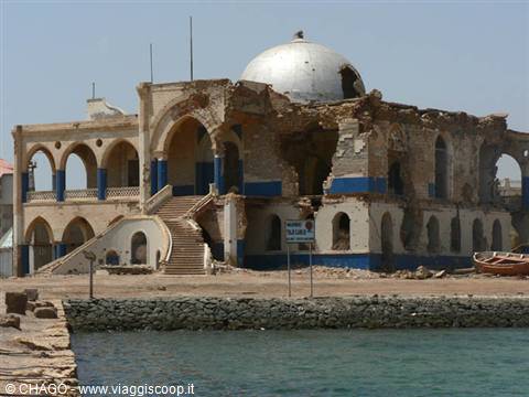 Ruined domed building with arches and blue pillars on Massawa waterfront